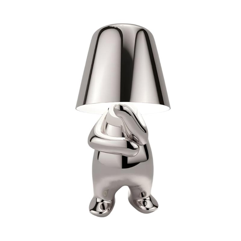 Silver figurine lamp standing with its arms folded across its chest