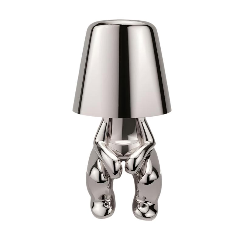 Silver figurine lamp standing to attention beneath the tapered shade