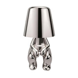Silver figurine lamp standing to attention beneath the tapered shade