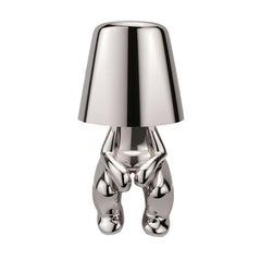 Silver figurine lamp standing to attention beneath the tapered shade