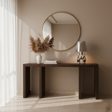 Silver figurine lamp lit on a dark console beneath a round mirror