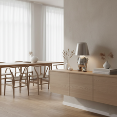 Silver figurine lamp lit on a sideboard behind a dining table
