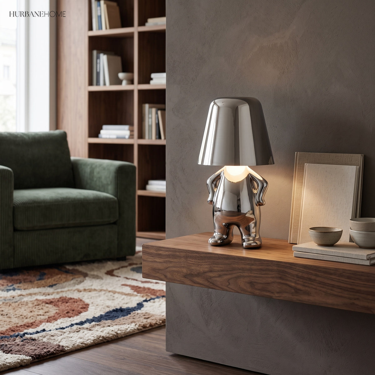 Silver figurine lamp lit on a wooden sideboard beside a green chair
