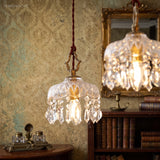 Two crystal pendant lights against a damask wallpaper wall