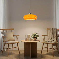 Two cream glass pendant lights above a long wooden dining table
