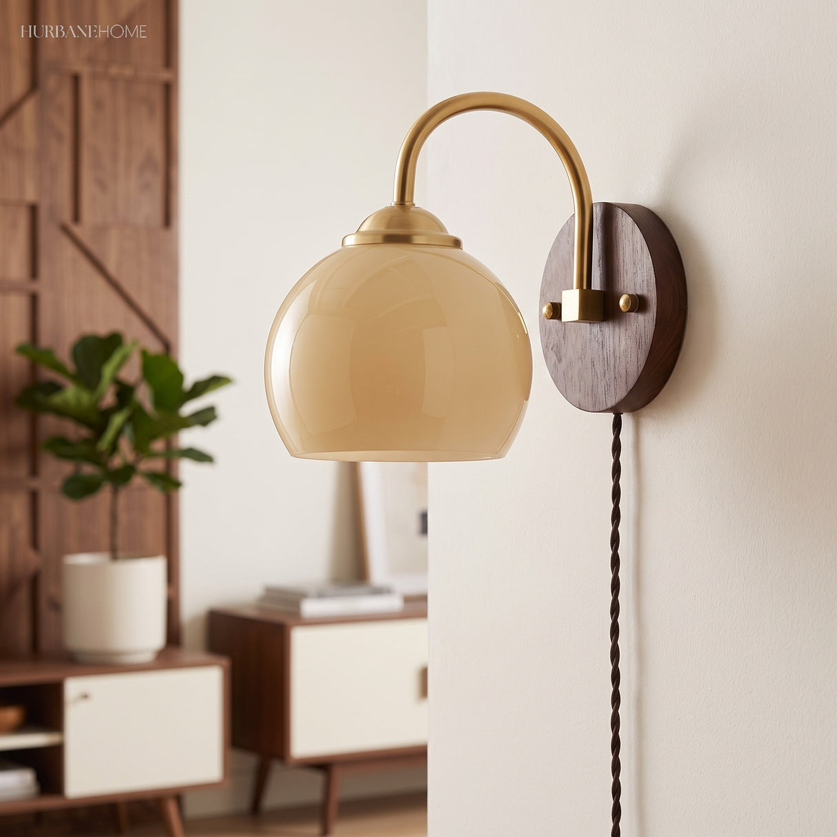 Cream dome glass sconce beside a mid-century console and potted plant
