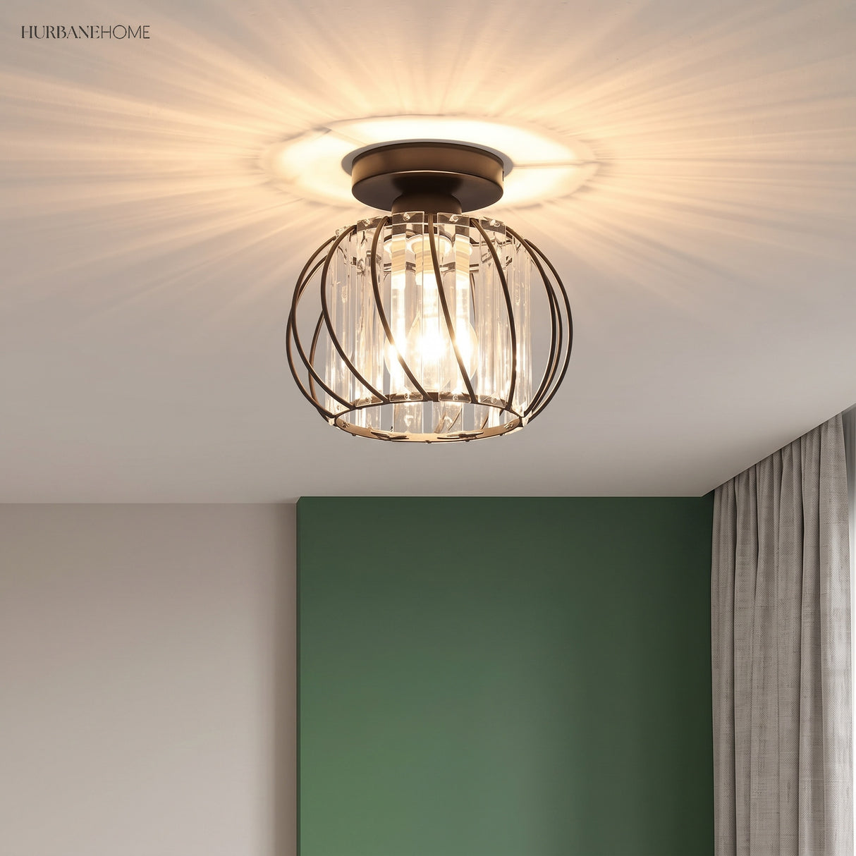 Black crystal cage ceiling light throwing starburst patterns above a green wall