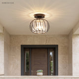 Crystal cage ceiling light above a stone clad entry with a timber front door