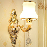Single light gold sconce with an opal glass shade and crystal drop
