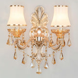 Gold candelabra sconce with pleated shades on a gray background