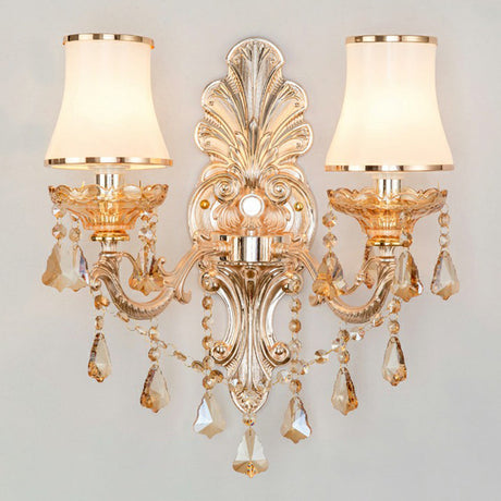 Gold candelabra sconce with pleated shades on a gray background