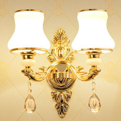 Gold two light sconce with opal glass shades on a cream backdrop