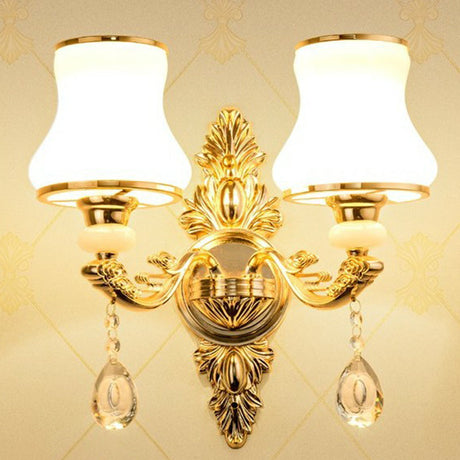 Gold two light sconce with opal glass shades on a cream backdrop