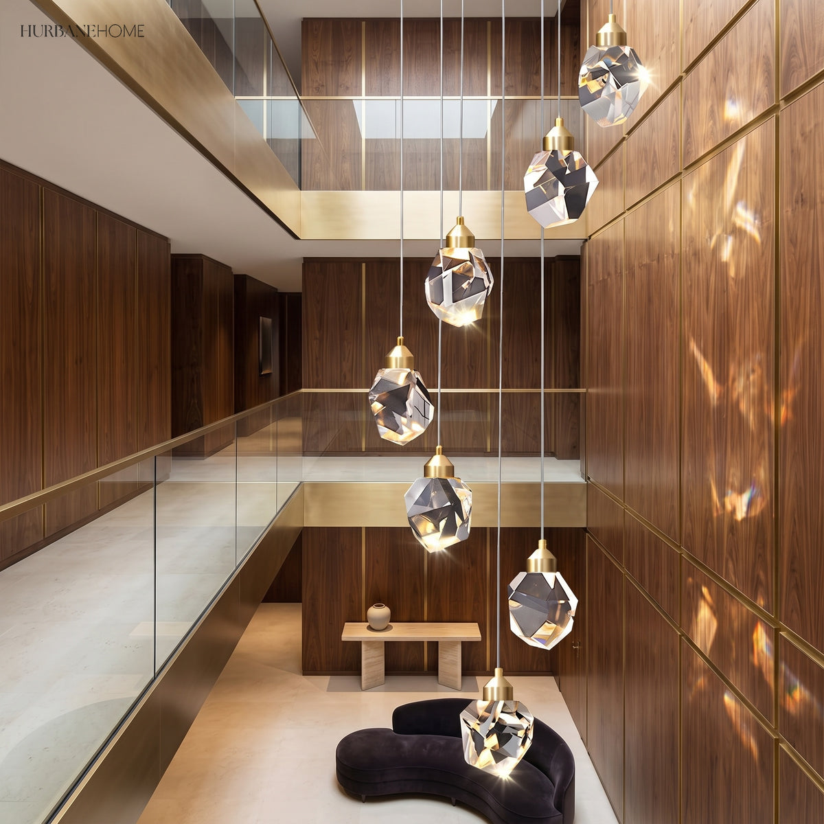 Faceted crystal globe pendant lit above a seating area in brass