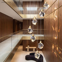 Faceted crystal globe pendant lit above a seating area in brass