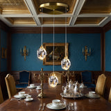 Three crystal pendants hung in a row above a dining table
