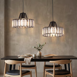 Two black framed crystal pendants above a dark dining table and timber chairs