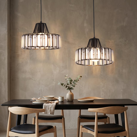 Two black framed crystal pendants above a dark dining table and timber chairs
