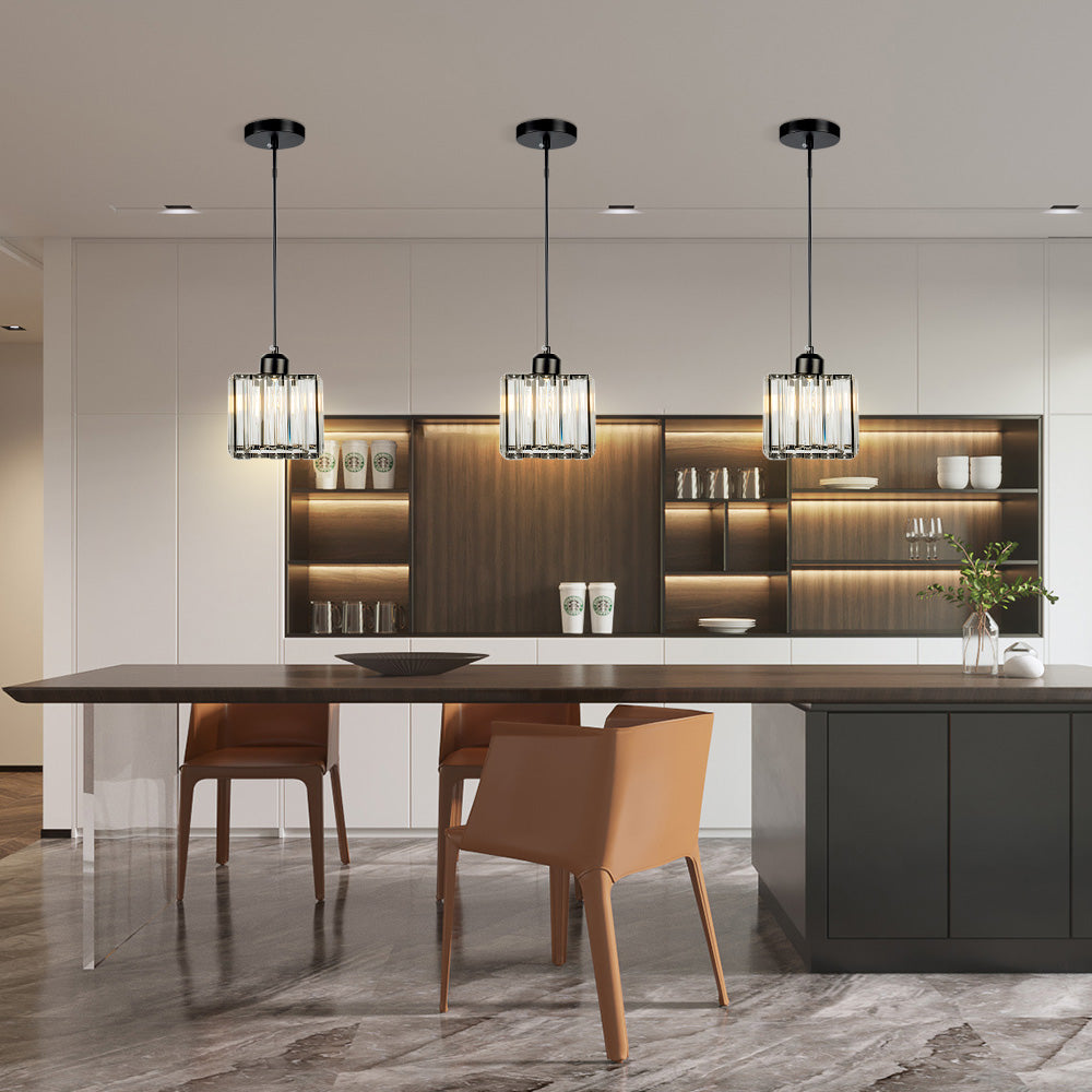 Three mini crystal pendants in a row above a long kitchen island
