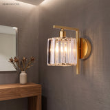 Crystal column sconce lit on a grey wall above a timber console