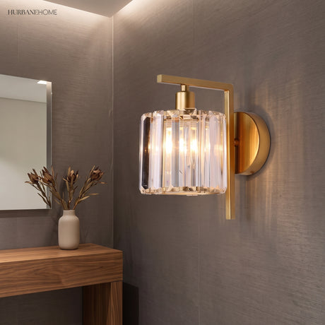 Crystal column sconce lit on a grey wall above a timber console