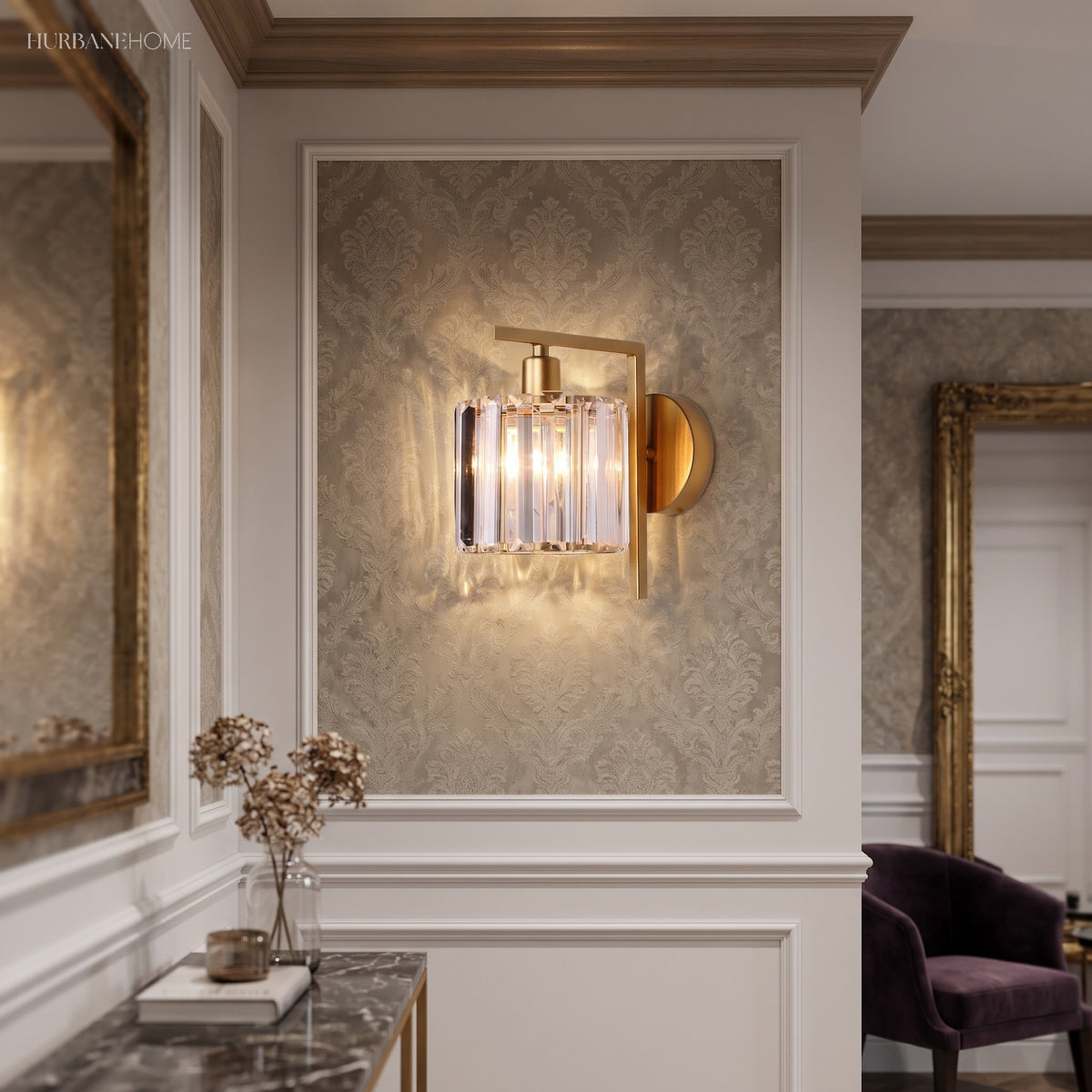 Crystal column sconce lit in a panelled hall beside a side table