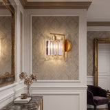 Crystal column sconce lit in a panelled hall beside a side table