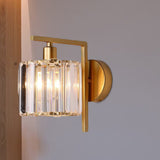 Crystal column sconce lit at an angle on a plain white wall