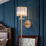 Gold sconce with a crystal shade on a deep blue panelled wall