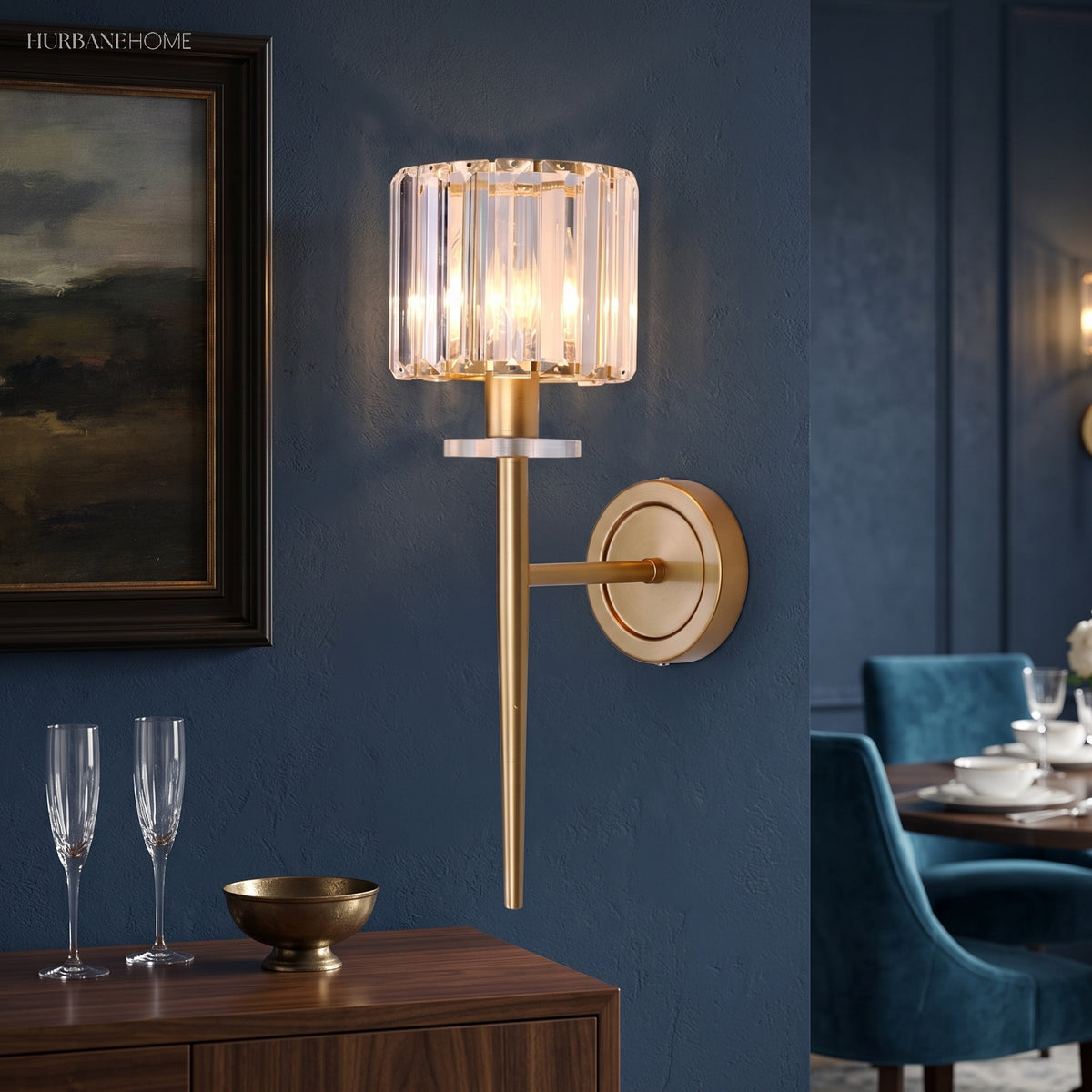 Crystal sconce lit beside an oil painting and champagne flutes
