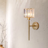 Crystal sconce lit on a pale plaster wall beside bare branches