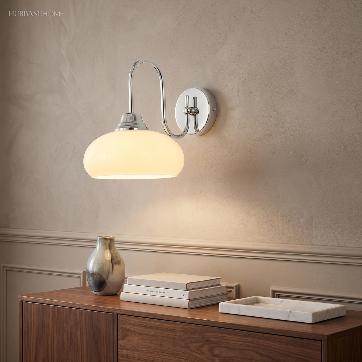 Chrome curved glass wall sconce above a walnut sideboard