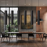 Black tube pendants above a long dining table in an open room