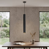 Black tube pendant hanging above a dining table by a window