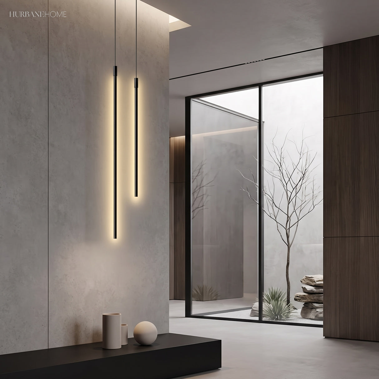 Two black cylinder pendants glowing warm against concrete by a courtyard