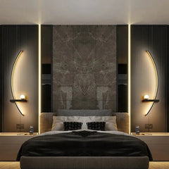 Curved LED wall light casting a soft warm glow in a dark bedroom