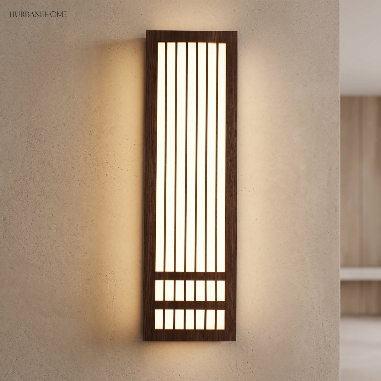 Tall dark walnut wood wall sconce casting warm light on a plaster wall