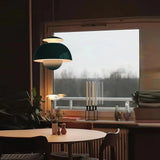 Glossy metal bud pendant light casting a soft glow in a dim room