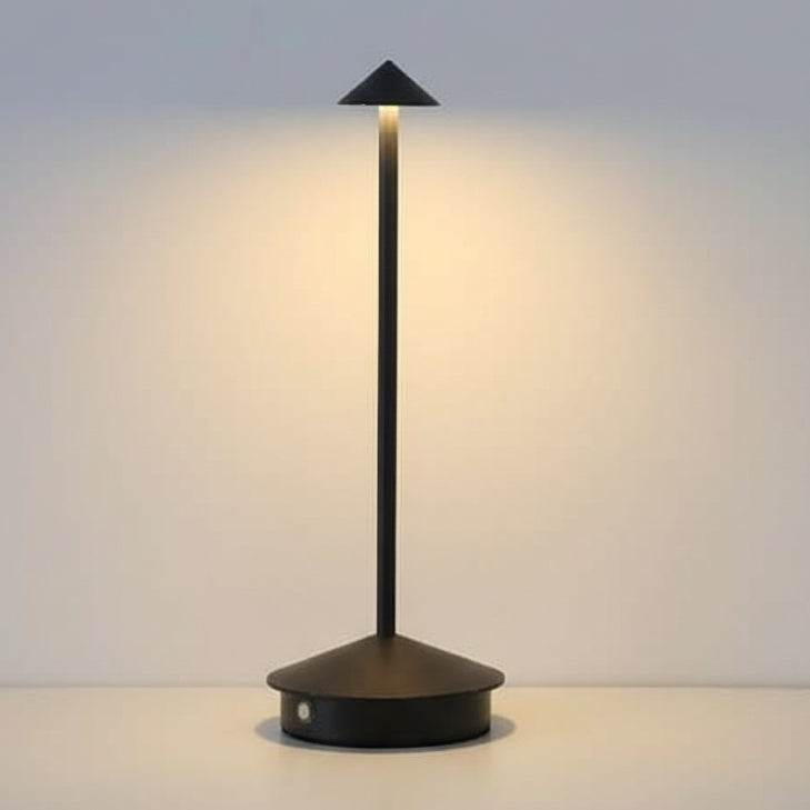 Portable LED table lamp lighting a bedside nightstand in warm tones
