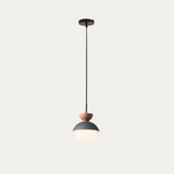Dark blue macaron pendant light casting soft light on a plaster wall