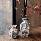 Decorative ceramic vase styled with fresh white flowers on shelf
