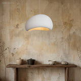 Single white dimmable pendant light glowing above a wooden console