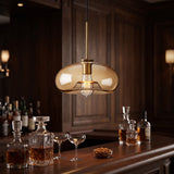 Amber glass pendant lighting a whisky bar counter in a paneled room