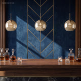 Three amber globe pendants over a table against a blue chevron wall
