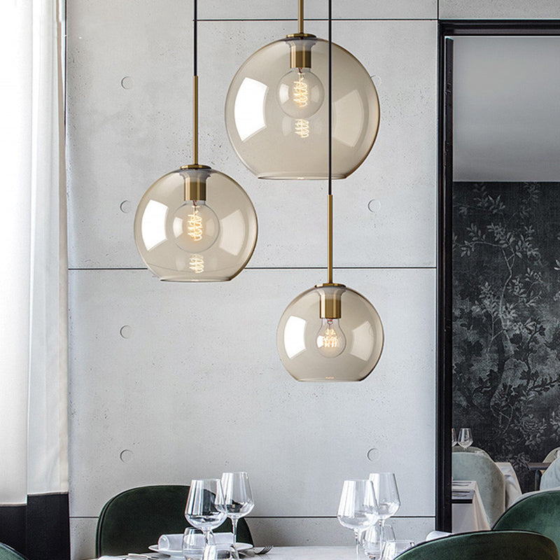 Amber glass pendants above a dining table beside a tall window