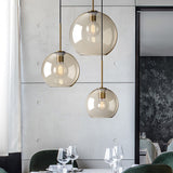 Amber glass pendants above a dining table beside a tall window
