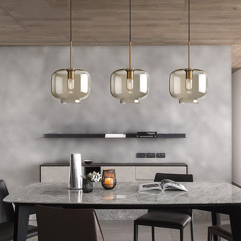 Three amber pendants above a marble kitchen island and stools