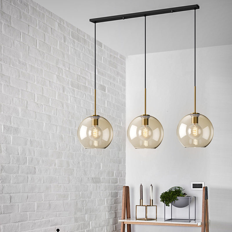 Three amber pendants over a table against a white brick wall