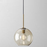 Studio shot of the mid size amber glass globe pendant lit warm
