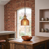 Orange gridded pendant lit in a brick alcove above a timber counter